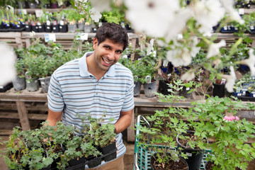 Man holding rack of potted plants