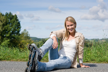 Inline skates young woman sitting asphalt road