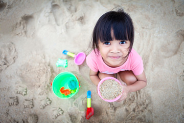 Little Girl Making Sand on the Beach
