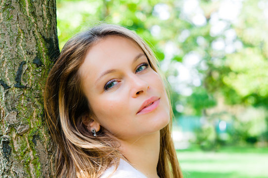 beautiful young attractive woman outdoors portrait on green back