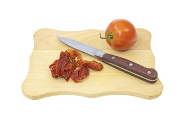 Sun dried tomatoes on cutting board with knife