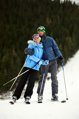 Portrait of cheerful young couple on skis