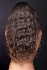 Woman with long curly hairs, back, brunette