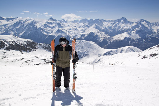 Young skiing man standing in snow mountain landscape