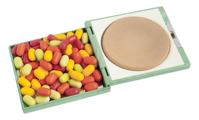 Multi-coloured tablets  pills  lie in a female powder box