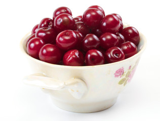 Bowl with ripe cherries. Isolated on a white background.