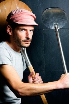 Pizzaiolo avec des pelles &agrave; pizza