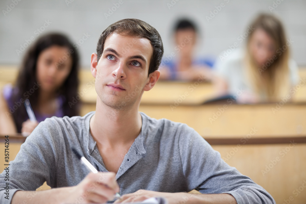 Poster students taking notes in an amphitheater