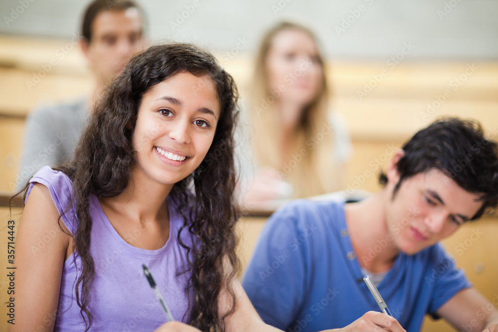 Poster smiling student taking notes