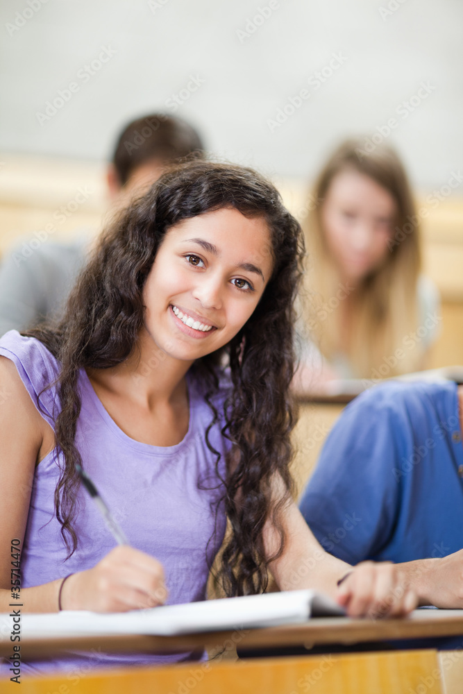 Poster portrait of a smiling student taking notes