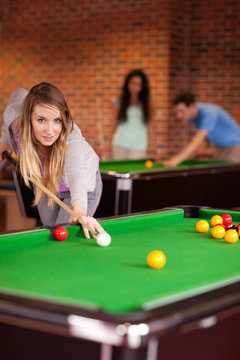 Portrait of a student woman playing snooker