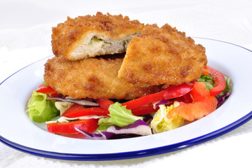 Chicken Kiev mit Salat der Saison auf einem Teller