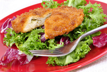 Chicken Kiev mit gemischtem Blattsalat und einer Gabel