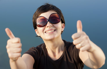 Young brunette girl  making thumbs up gesture