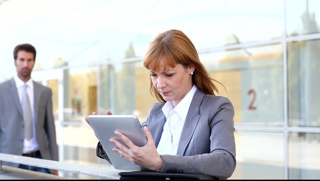 Business people working outside on electronic tablet