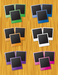 Groups of instant photos in different colors on wood background