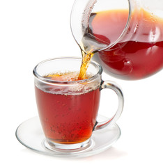 Tea being poured into tea cup isolated on a white background