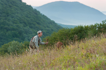 Hunter with dog in countryside