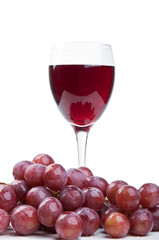 a glass of wine and red grapes