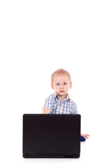 Little boy sitting with laptop over white background