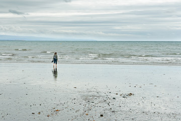 Woman at Criccieth beach in Wales, UK