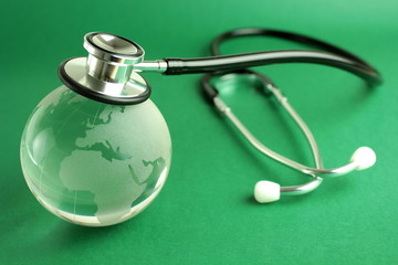 Stethoscope and world - green background