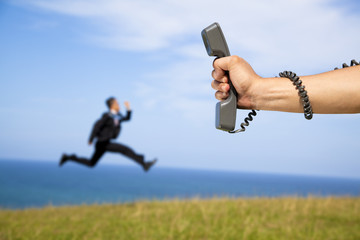 hand holding phone and running businessman