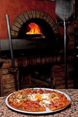 Ready-made pizza waiting in front of the oven