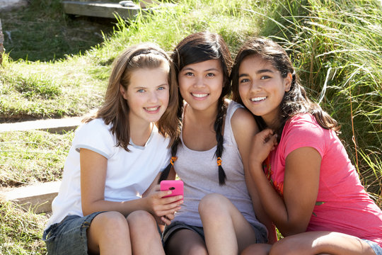 Teenage girls using phone outdoors