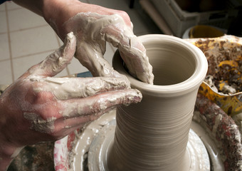 hands of a potter, creating an earthen jar on the circle