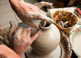 hands of a potter, creating an earthen jar on the circle