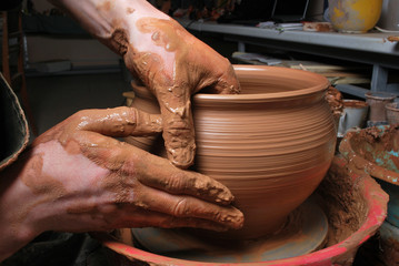 hands of a potter, creating an earthen jar on the circle