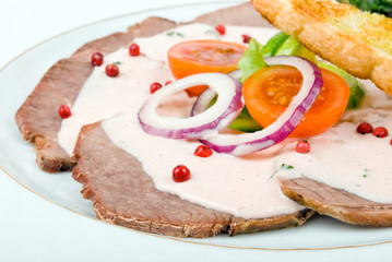 roast meat served with vegetables over white