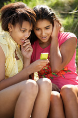 Teenage girls using phone outdoors