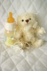 Teddy bear and bottle with milk