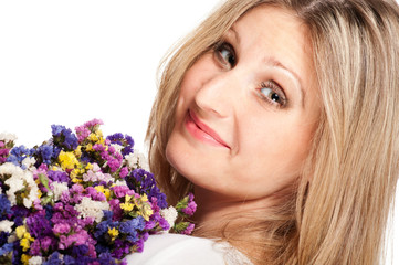 Blonde woman turning with bouquet of field flowers