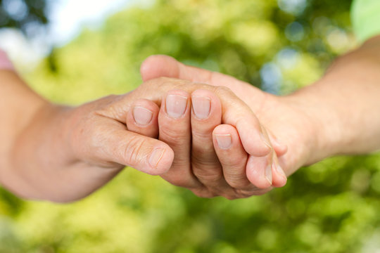 Closeup of senior hands holding together