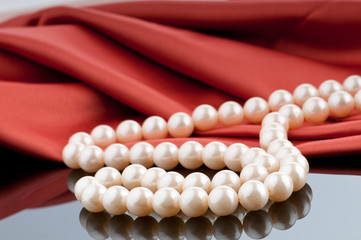 Pearls necklace on satin background