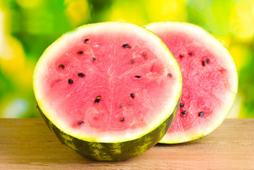Ripe sweet watermelon on wooden table on green  background