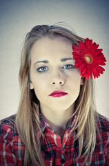 portrait of young beautiful woman with red flower in her hair