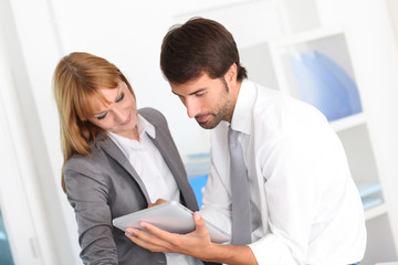 Business people in office using electronic tablet