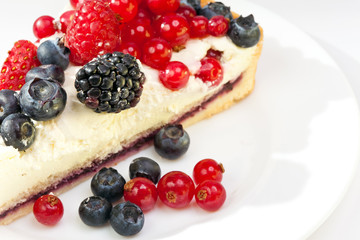 Piece of a pie with fresh berries on a plate