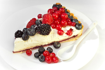 Piece of a pie with fresh berries on a plate