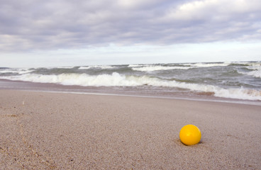 yellow ball on the sea beach sand
