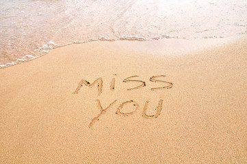 Miss you text written on the beach sand - obrazy, fototapety, plakaty