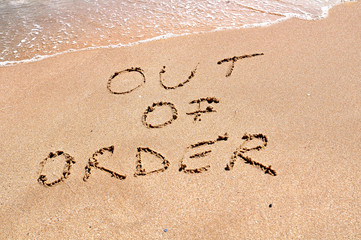 Out of order text written on the beach sand