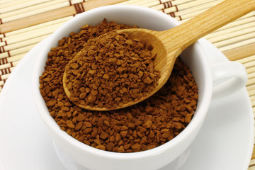 Cup of ground coffee with wooden spoon