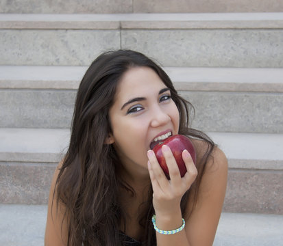 Jovencita comiendo manzana roja