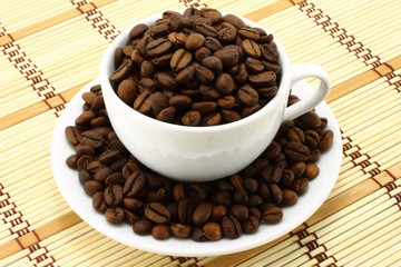 Coffee cup with coffee beans on a wooden background