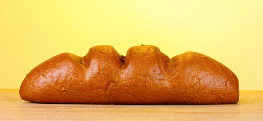 rye bread on wooden table on yellow background